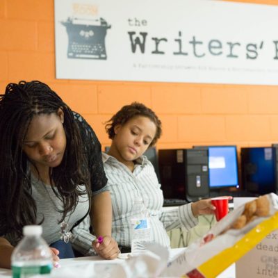two people highlighting papers at the Writers' Room