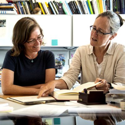 two women looking at books together