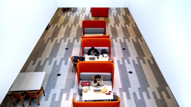 students in snell library studying in orange lounge chairs