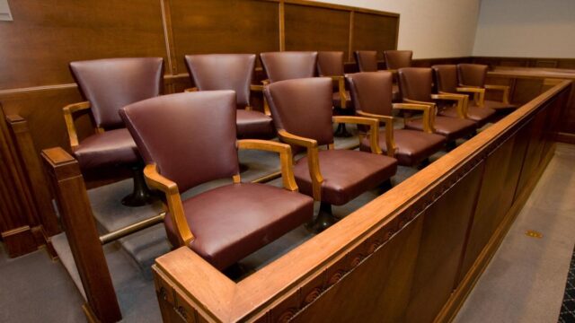 two rows of brown leather jury chairs in a courtroom