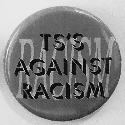 a black and grey image of a button/pin reading 