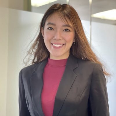 headshot of Christie Lee wearing a black blazer and a fuschia turtleneck