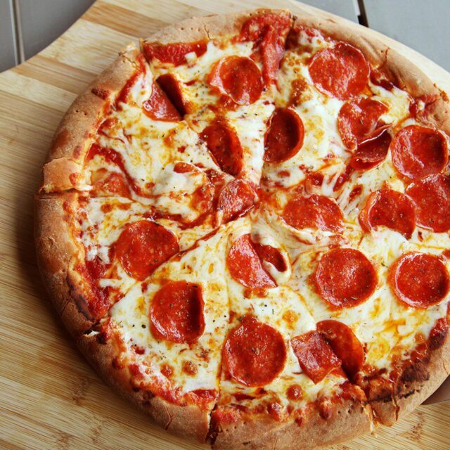 Pepperoni pizza on a wooden pizza peel.