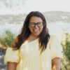 Dayna Altman in a yellow dress smiling at the camera lens.