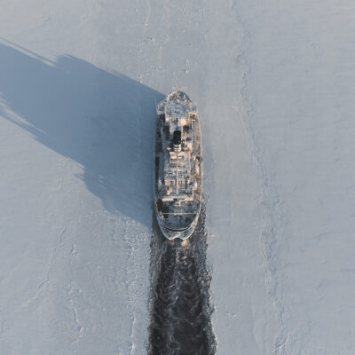 The icebreaker makes a route in the ice fields. Air view.