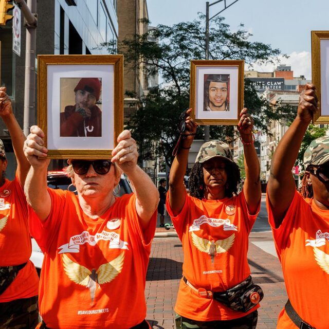 COLUMBUS, OHIO, UNITED STATES - 2021/08/01: Mothers of Murdered Columbus Children stand at the intersection of High Street and Broad Street while holding pictures of their deceased children. In reaction to the rising violence since 2020 Malissa Thomas-St. Clair, a mother of a murdered son, Anthony Thomas-St. Clair, founded Mothers of Murdered Columbus Children (MOMCC), an anti-violence group seeking to end violent crime in Columbus, Ohio. MOMCC led the effort for a Central Ohio Anti-Violence March & Rally at City Hall featuring many other mothers who lost children to violence, the Ceasefire initiative led by Al Edmondson and many other community and governmental leaders. The rally and March started off with many speakers, concluding a march around downtown, and a benediction by Pastor Michael Young. (Photo by Stephen Zenner/SOPA Images/LightRocket via Getty Images)