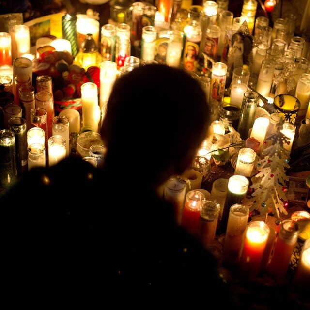 Candles line a sidewalk memorial in honor of the Sandy Hook Elementary School shooting victims, Tuesday, Dec. 18, 2012, in Newtown, Conn. (AP Photo/David Goldman)