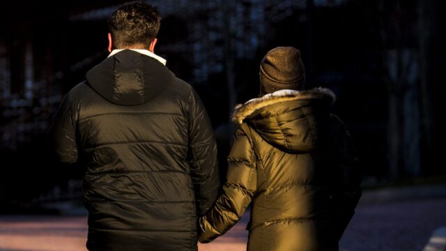 Members of the Northeastern campus walk by the Egan Research Center holding hands on Tuesday, Jan. 4, 2022.