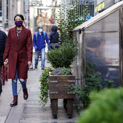 Diners sit inside a semi-transparent sidewalk housing at a restaurant while observing social distancing protocols to combat the spread of COVID-19