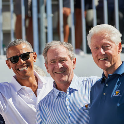 Presidents Obama, G.W. Bush, and Bill Clinton smile and wave while on the first tee during the first round of the Presidents Cup at Liberty National Golf Club on September 28, 2017 in Jersey City, New Jersey.