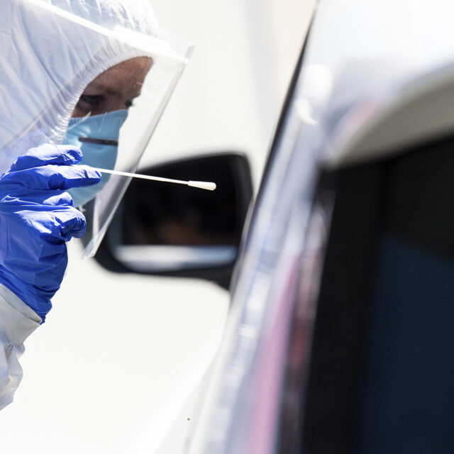 Employees of the Bavarian Red Cross take a smear test at a corona test centre on the motorway 8 (A8) at the Hochfelln-Nord rest area.