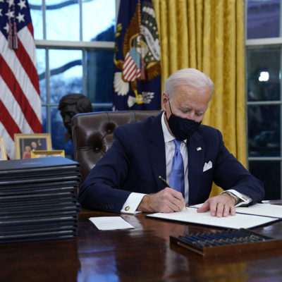President Joe Biden signs his first executive order in the Oval Office of the White House on Wednesday, Jan. 20, 2021, in Washington. 