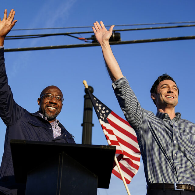 Georgia Democratic candidates for U.S. Senate Raphael Warnock, left, and Jon Ossoff, right, gesture toward a crowd during a campaign rally on Sunday, Nov. 15, 2020, in Marietta, Ga.