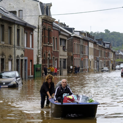 People use a boat to bring man out of home following a severe storm on July 16, 2021 in 'Rue de Tilff' in Angleur, a district from Liège, Belgium.