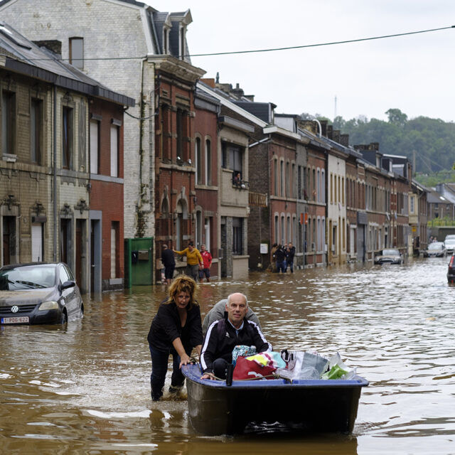 People use a boat to bring man out of home following a severe storm on July 16, 2021 in 'Rue de Tilff' in Angleur, a district from Liège, Belgium.