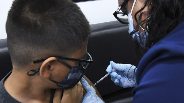 A nurse administers a shot of the Pfizer COVID-19 vaccine to Daniel Castaneda, 12, at a mobile vaccination site at Oak Ridge High School on May 22, 2021 in Orlando, Florida.