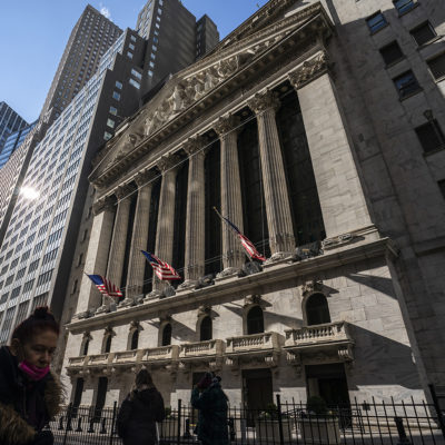 Pedestrians walk past the New York Stock Exchange, Monday, Jan. 24, 2022, in New York.