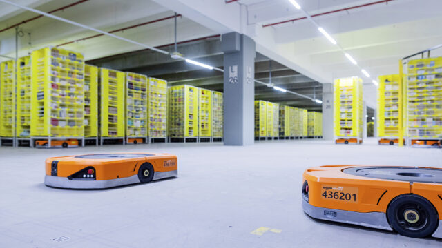 08 December 2020, North Rhine-Westphalia, M'nchengladbach: Robots transport goods to the employees in the warehouse of a logistics centre of the mail order company Amazon. A particularly large number of orders are processed during the Christmas business.