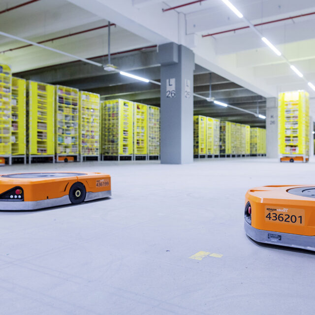 08 December 2020, North Rhine-Westphalia, M'nchengladbach: Robots transport goods to the employees in the warehouse of a logistics centre of the mail order company Amazon. A particularly large number of orders are processed during the Christmas business.