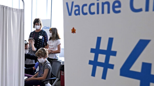 Graham Roark, 8, receives the Pfizer COVID-19 vaccine for children 5 to 11 years from Lurie Children's hospital registered nurse Virginia Scheffler at the hospital Nov. 5, 2021, in Chicago.
