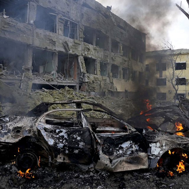 A car burns at the side of the damaged by shelling maternity hospital in Mariupol, Ukraine, Wednesday, March 9, 2022.