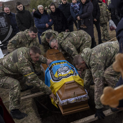The coffin of senior police sergeant Roman Rushchyshyn is lowered during his funeral in the village of Soposhyn, outskirts of Lviv, western Ukraine, Thursday, March 10, 2022, in Lviv.