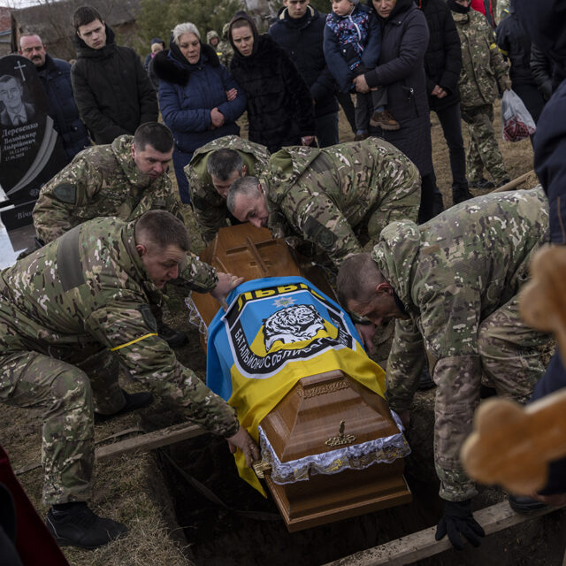 The coffin of senior police sergeant Roman Rushchyshyn is lowered during his funeral in the village of Soposhyn, outskirts of Lviv, western Ukraine, Thursday, March 10, 2022, in Lviv.