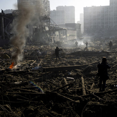 People gather amid the destruction caused after shelling of a shopping center, in Kyiv, Ukraine, Monday, March 21, 2022.