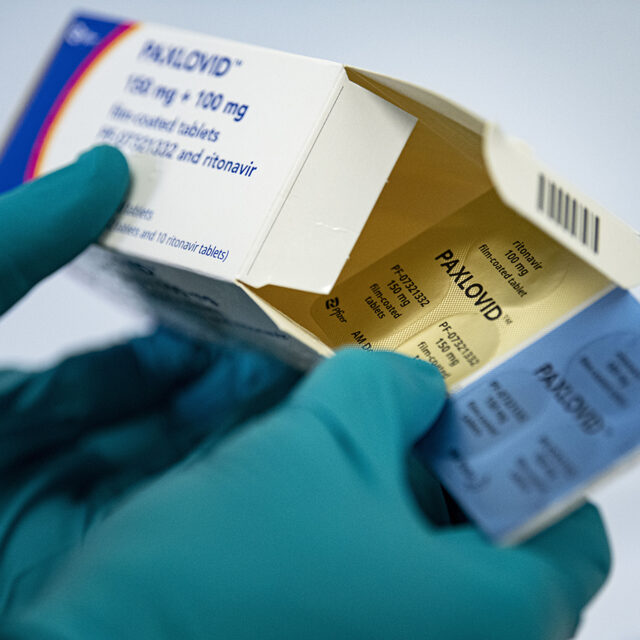 01 March 2022, Berlin: A person holds the drug Paxlovid against Covid-19 from the manufacturer Pfizer.