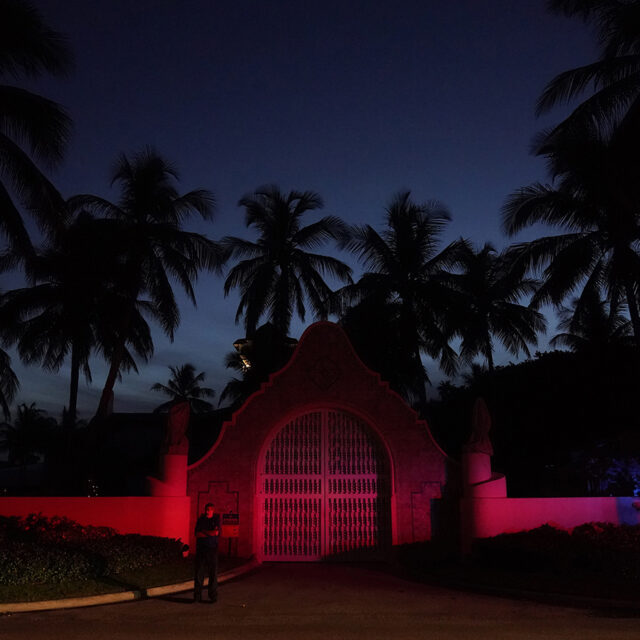 A man stands outside an entrance to former President Donald Trump's Mar-a-Lago estate, Monday, Aug. 8, 2022, in Palm Beach, Fla. Trump said in a lengthy statement that the FBI was conducting a search of his Mar-a-Lago estate and asserted that agents had broken open a safe.