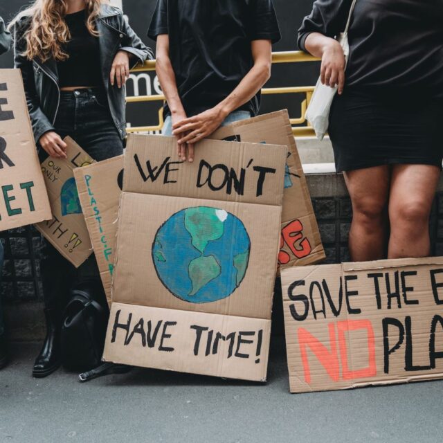 People are holding banner signs while they are going to a demonstration against climate change. Protest against global warming. Climate change protest concept.