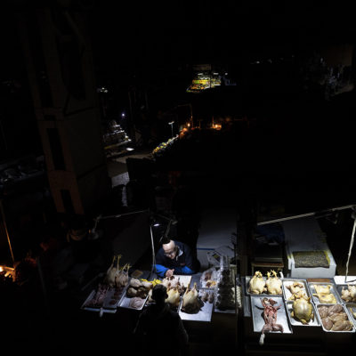Vendors wait for customers inside a market during a power outage in central Kyiv, Ukraine, Wednesday, Nov. 9, 2022.