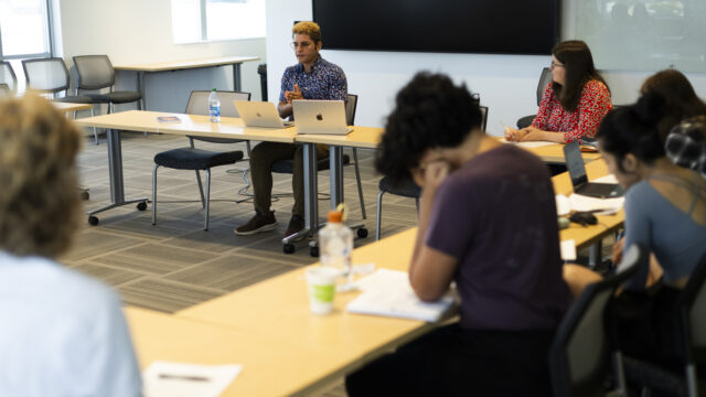 Graduate students in the summer long AI and data ethics research program present to one another in Renaissance Park.