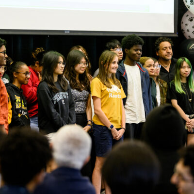 Graduating students of the Bridge to Calculus program smile onstage during graduation.