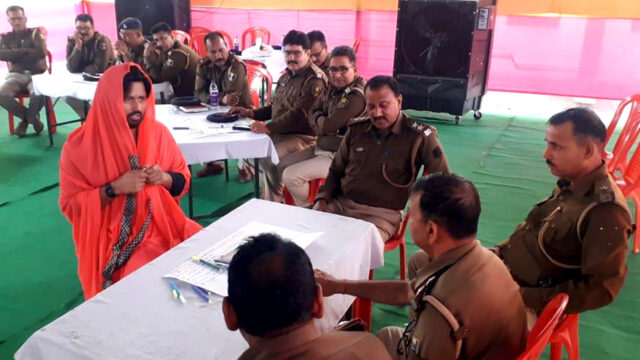 Policemen gathered around a table, participating in training program.
