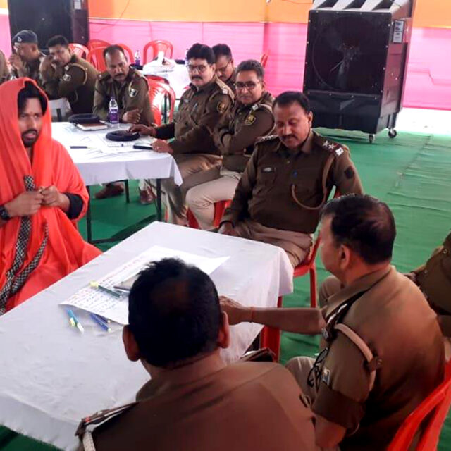 Policemen gathered around a table, participating in training program.