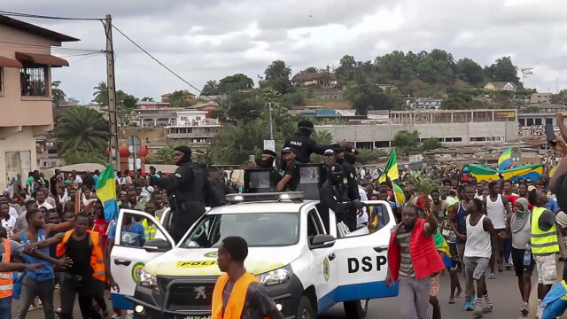 This video grab shows coup supporters cheering police officers in Libreville, Gabon, Wednesday Aug. 30, 2023. Mutinous soldiers speaking on state television announced that they had seized power in and were overturning the results of a presidential election that had seen Gabon President Ali Bongo Ondimba extend his family’s 55-year hold on power. ( AP Photo/Betiness Mackosso)