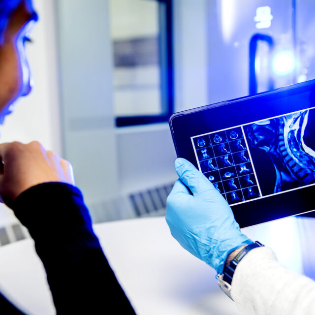 Woman looking at test results on an iPad that a Doctor is holding.