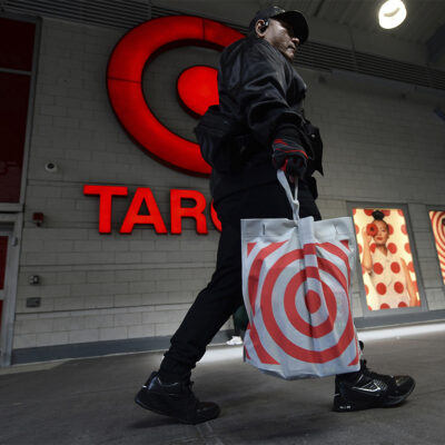 A shopper walks past the Target store logo affixed to the Harlem location, one of 9 locations set to close announced by discount retailer, New York, NY, September 27, 2023.
