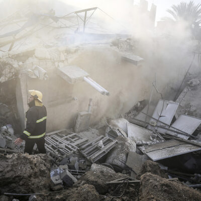 Palestinian men walk amidst the rubble of a UNRWA school in Gaza City, which was destroyed overnight in an Israeli airstrike on October 8, 2023.