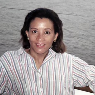 Zandra I. Flemister on the Connecticut River, 1997. She smiles on a boat, wearing a white shirt with black stripes.