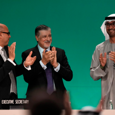 Sultan al-Jaber of the United Arab Emirates, right, celebrates the end of the COP28 climate meeting with United Nations Climate Chief Simon Stiell, left, and COP28 CEO Adnan Amin on Dec. 13, 2023, in Dubai.