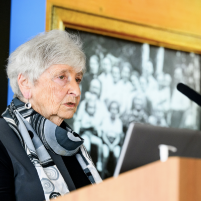eva paddock speaking at a podium with microphone