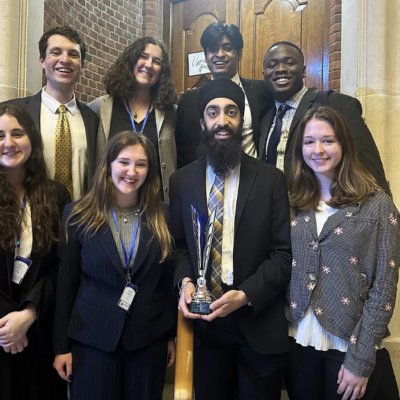 image of the 8 students from Northeastern’s Boston-based International Relations Council holding the award they won for their work during a model UN conference in London.