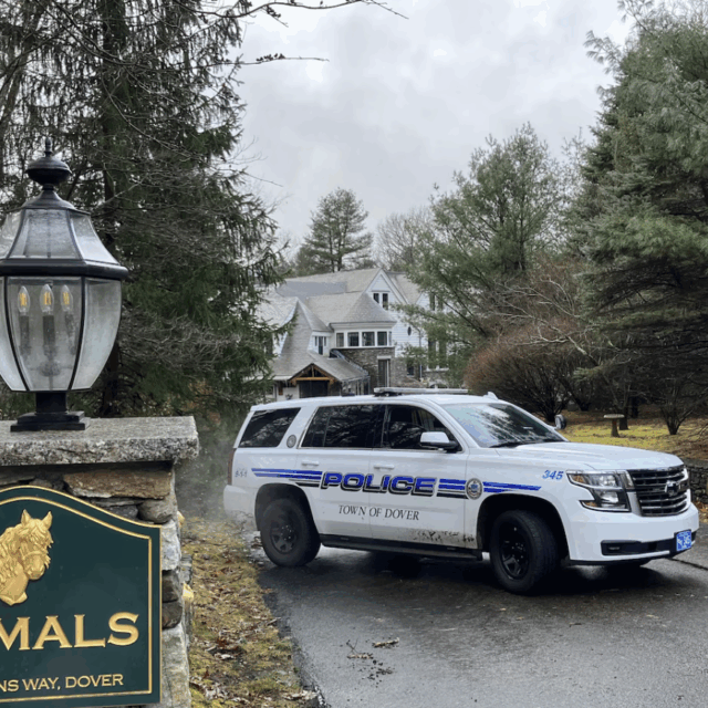 image of police cruiser outside of home with the caption: The mansion at 8 Wilson's Way in Dover owned by the Kamal family. Three members of the Kamal family — mother, father and daughter — were found dead in December 2023 in a murder-suicide.