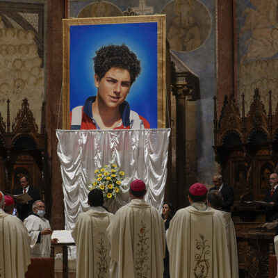An image of 15-year-old Carlo Acutis, an Italian boy who died in 2006 of leukemia, is unveiled during his beatification ceremony celebrated by Cardinal Agostino Vallini in the St. Francis Basilica, in Assisi, Italy, Saturday, Oct. 10, 2020. (AP Photo/Gregorio Borgia)