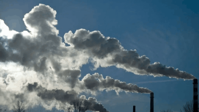 Smoke stacks releasing smoke into the atmosphere. (Earth.org)