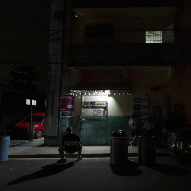A lamp powered by a generator illuminates a sidewalk during a blackout in San Juan, Puerto Rico, after sunset Tuesday, Dec. 31, 2024. (AP Photo/Alejandro Granadillo)