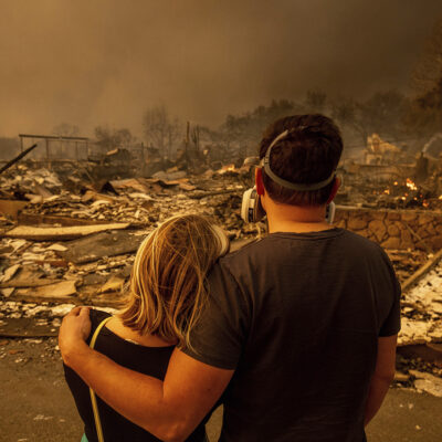 Megan Mantia, left, and her boyfriend Thomas, return to Mantia's fire-damaged home after the Eaton Fire swept through, Wednesday, Jan. 8, 2025, in Altadena, Calif. (AP Photo/Ethan Swope)