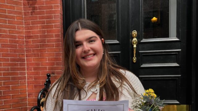 Girl holding award certificate and smiling